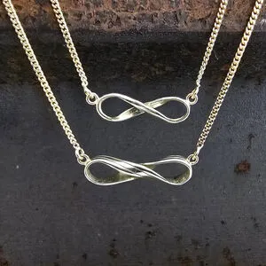 Zilveren hangers met oneindigheids-symbool op leisteen